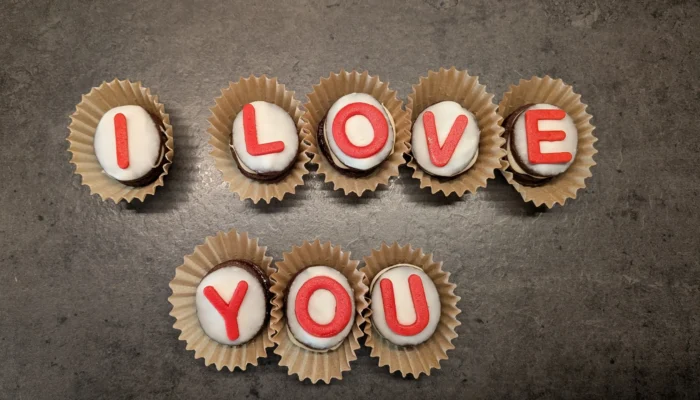 Plätzchen mit Buchstaben aus Zuckergussschrift zusammengelegt zu dem Satz "I love you"