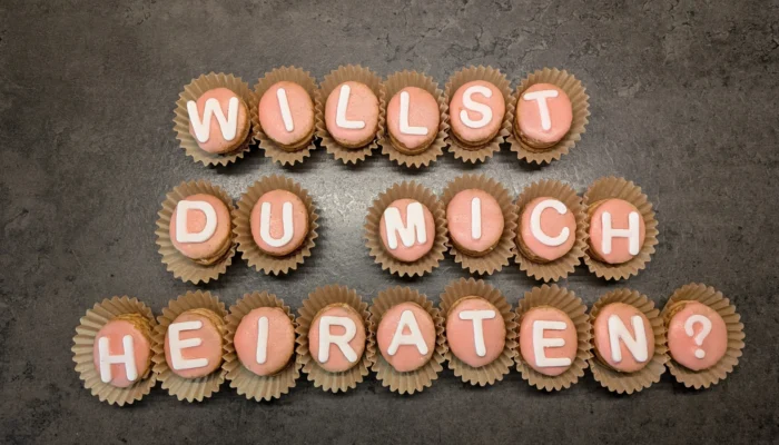 Plätzchen mit Buchstaben aus Zuckergussschrift zusammengelegt zu dem Satz "Willst du mich heiraten?"