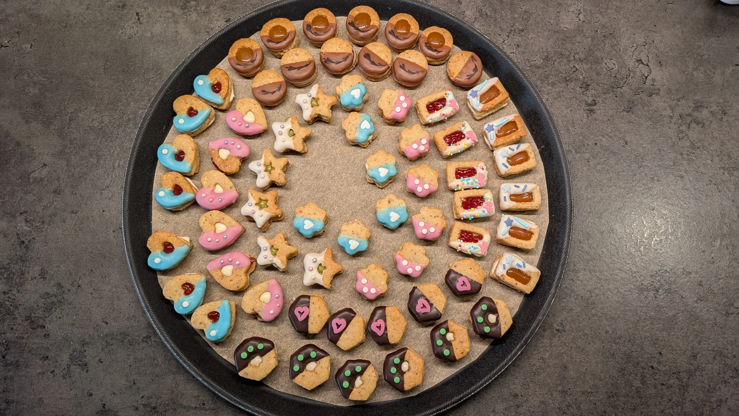 verschieden dekorierte Plätzchen auf einem Präsentierteller im Kreis angeordnet